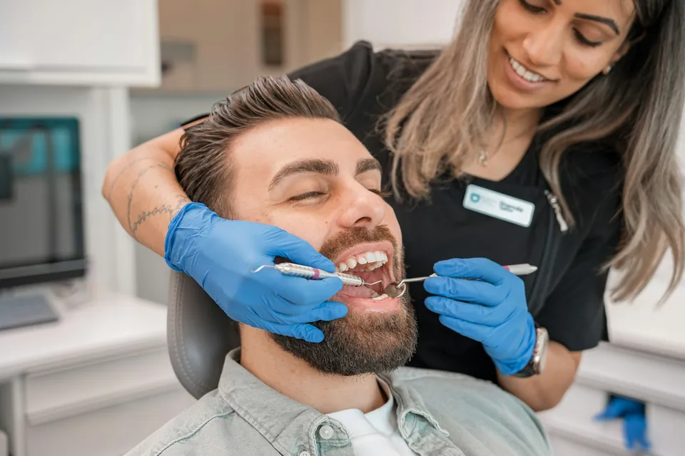 Dentist working on a patient's front teeth in a modern treatment room