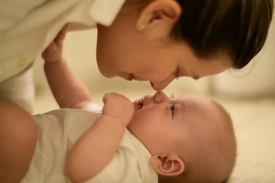 Parent holding a young infant close, face to face
