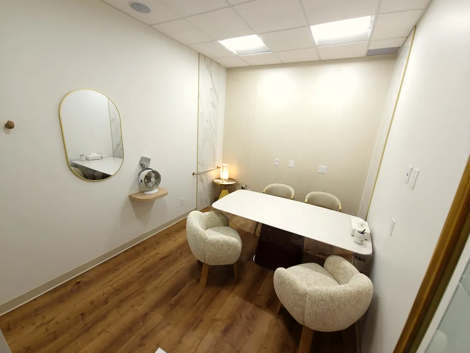 Private enclosed consultation room with a gold-framed mirror and a personal fan at Monaco Dentistry