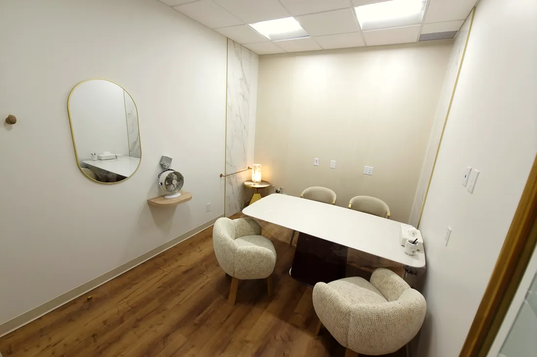 Consultation room with a large gold-framed mirror at Monaco Dentistry